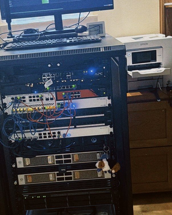 The Lab’s computer rack at home, cables and lights on, with a screen on top