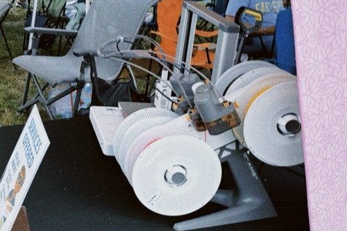 A Lab printer's filament spools lined up on the stall table, ready to print