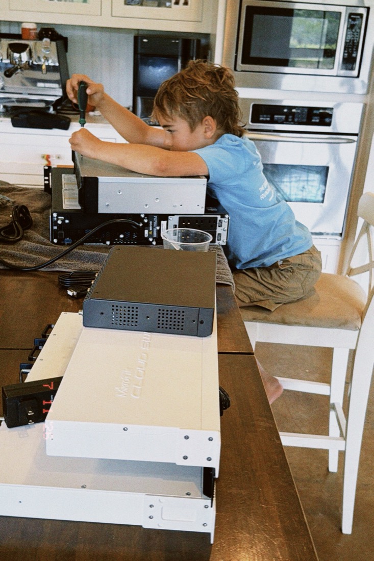 Joseph working with a screwdriver on rack-mounted equipment