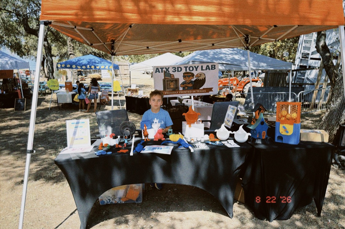 Joseph behind the Texas Toy Lab market stall, table covered in 3D printed toys